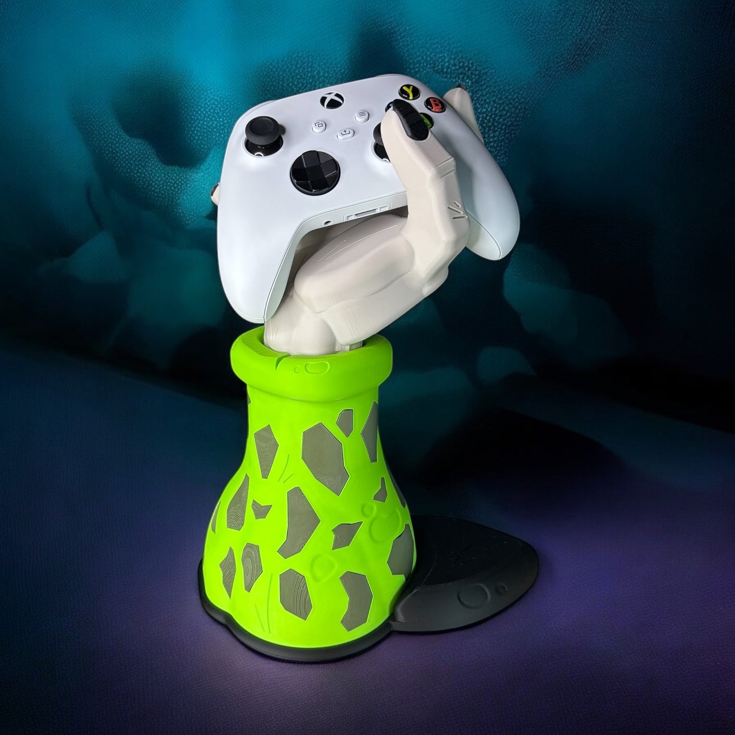 Gaming controller held by a white hand in a green and gray glove against a dark background